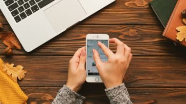 New York - 10 Eylül 2017: Bir araba, taksi sipariş için Uber app kullanan kadın. Kartı, nakit ödeme. Ahşap masa arka plan. Üstten Görünüm