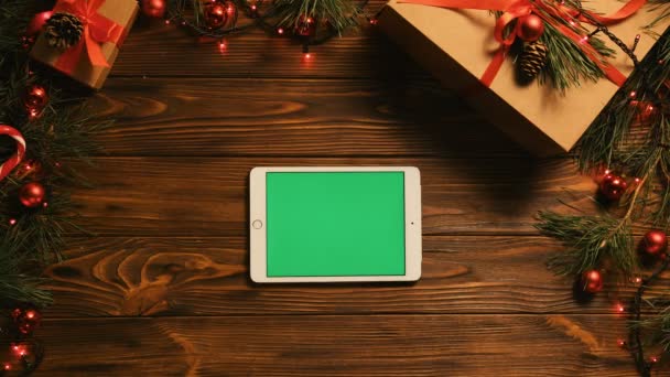 Conceito de Natal. Vista superior. dispositivo tablet branco com tela verde na velha mesa de madeira com decoração de Natal feriado. Chave Chroma. Posição horizontal — Vídeo de Stock