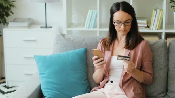 Mujer usando móvil y tarjeta de crédito — Vídeos de Stock