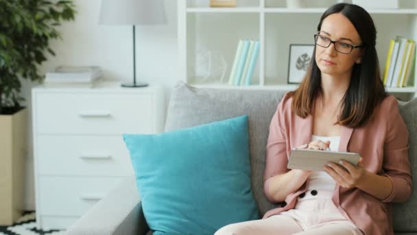 Brunetka kobieta za pomocą cyfrowego tabletu — Wideo stockowe