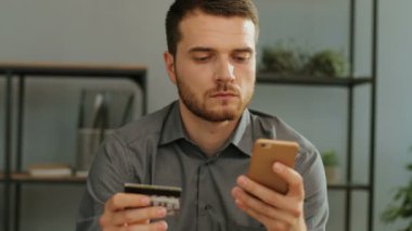 telefon ve kredi kartı tutan adam