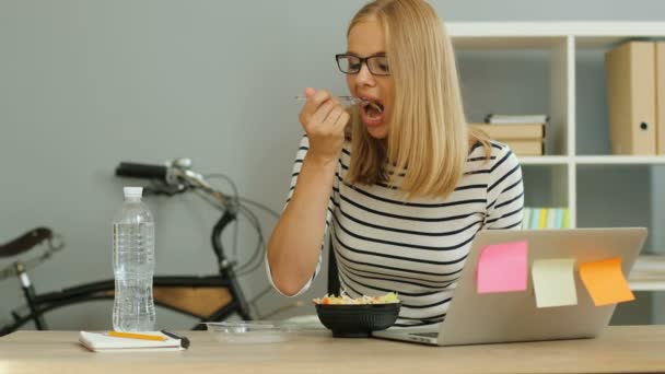 Mujer de negocios comer cerca de la computadora — Vídeo de stock