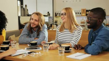 Çok ırklı kadınların bir Grup sohbet ve eğleniyor birlikte bir gündüz bir rahat şehir kafede bir adam bir kadeh yan. Yakın çekim.