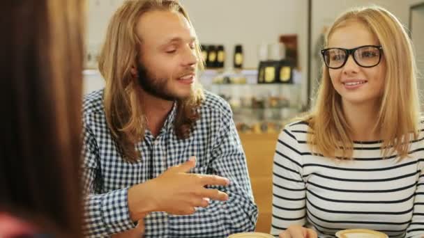 Un primo piano di giovani coppie caucasiche che chiacchierano nella caffetteria della città. Indoor shot . — Video Stock