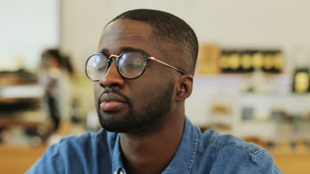 Portrait en gros plan d'un garçon afro-américain portant des lunettes de vue latérale puis à la caméra, souriant . — Video