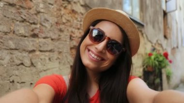 Mutlu çekici kadın kameraya komik surat. Şapka ve güneş gözlüğü selfies açık havada alarak kadında. Yakın çekim. Portre vurdu