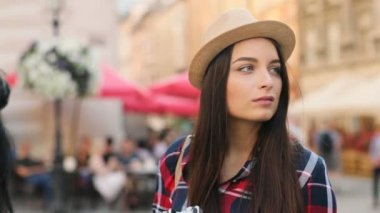 Açık havada şehirde eski sokak kameraya gülümseyen genç çekici Kafkas kadın portre çekim kapatın. Turist.