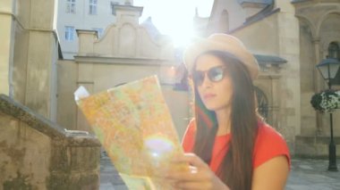 Beyaz olan kadın turist Haritası eski güzel sokaklarda yürürken için doğru hedef arıyor. Güneş ışınları. Yakın çekim