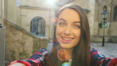 Kamera ve alma selfies açık havada eski sokağın ortasında gülümseyen genç neşeli kadın. Güneş ışınları. Seyahat kadın. yakın çekim