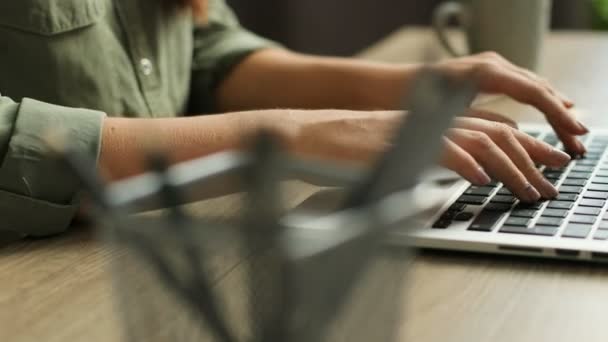 Close up vídeo de mãos femininas digitando no teclado do laptop em uma mesa de madeira moderna. Dedos batendo no teclado — Vídeo de Stock