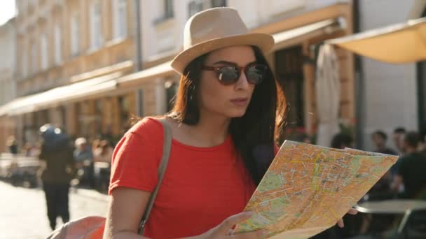 Giovane turista donna passeggiando per la strada con mappa cartacea e cercando di trovare la strada giusta, luogo. Donna visita della città vecchia . — Video Stock