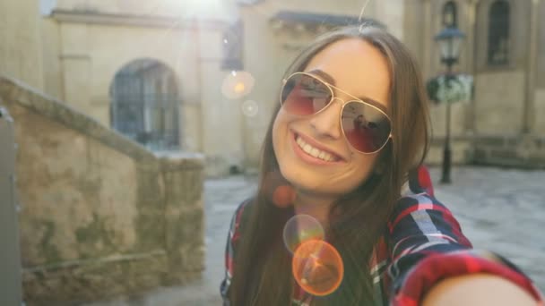 Ευτυχισμένη γυναίκα σε γυαλιά ηλίου, χαμογελώντας και κουνώντας στην κάμερα ενώ ταξιδεύετε. Γυναίκα βίντεο που κουβεντιάζει. Κοντινό πλάνο — Αρχείο Βίντεο