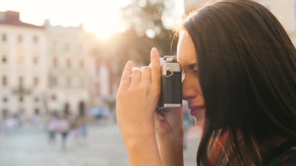 美しい若いブルネット女性の晴れた日に都市を旅しながら、美しい古い建物の写真を撮るします。クローズ アップ。サイド ショット — ストック動画