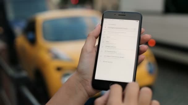 Nueva York - 20 de julio de 2017: Uber app. Mujer que usa la aplicación Uber para pedir un taxi en Los Ángeles. Al aire libre. Fondo borroso. De cerca. — Vídeos de Stock