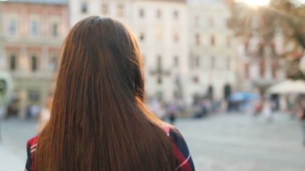 Feliz mujer sonriente girando y sonriendo a la cámara. De cerca. Al aire libre en la hermosa calle de la ciudad. Retrato plano — Vídeo de stock