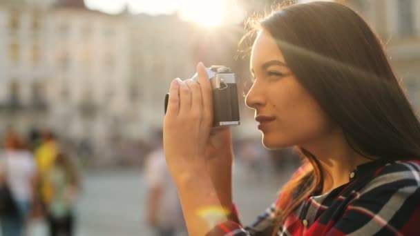 Mulher excitada tirando fotos na velha câmera vintage enquanto passeia pela cidade no dia ensolarado. Fecha. Ao ar livre — Vídeo de Stock