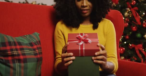 Mujer africana abriendo regalo de Navidad — Vídeos de Stock