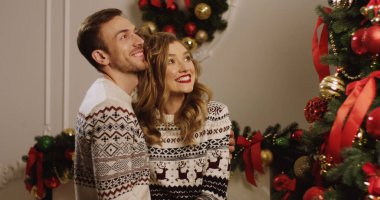 Rahat oturma odasında baubles ile Noel ağacı süsleme ve sarılma genç mutlu bir aile. Noel için hazırlanıyor. Yakın çekim. Portre