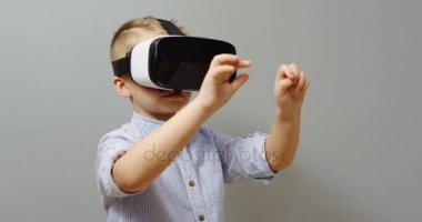 Vr gözlükle ve kaydırma ve onun önünde duvar arka plan üzerinde yakınlaştırma küçük çocuk portre vurdu. VR ayarlayın. İçinde