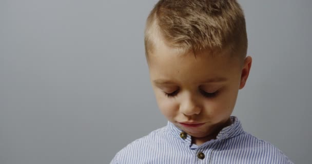 Primer plano del niño rubio triste limpiándose los ojos con una servilleta después de llorar. Retrato. Fondo de pared. De interior — Vídeos de Stock