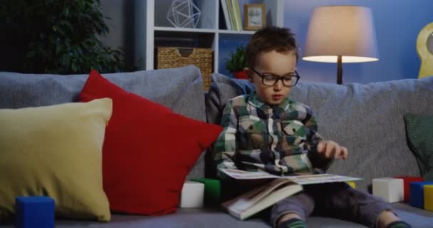 Schoolboy in glasses reading a book — Stock Video