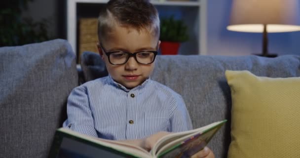 Estudante em óculos lendo um livro — Vídeo de Stock