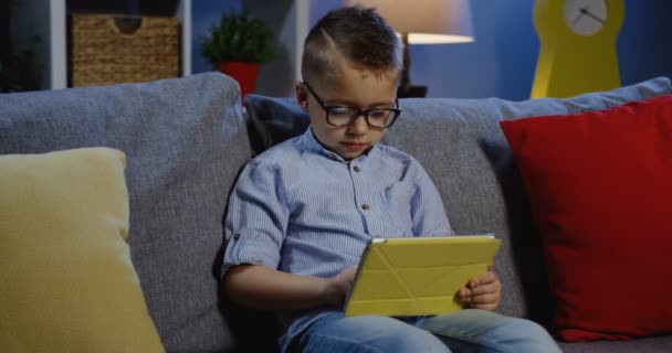 Школьник в очках, читающий книгу — стоковое видео