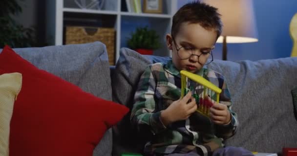 Colegial en gafas sentado en el sofá — Vídeos de Stock