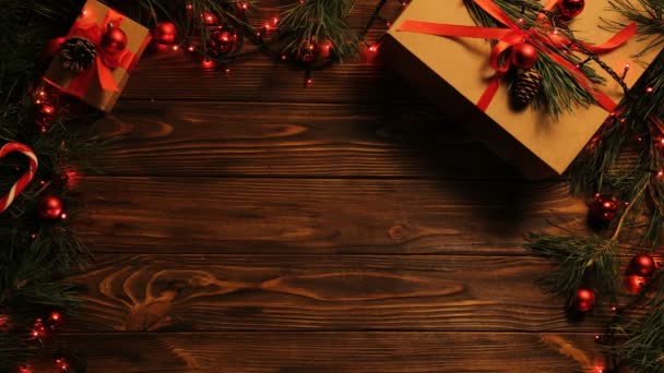 Top view. Wooden brown table decorated with Christmas stuff and garlands. Red Christmas lights. Close up. — Stock Video