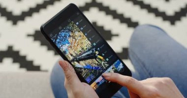 New York - 01 Aralık 2017: dikey olarak bir fotoğraf siyah akıllı telefonda Enlight uygulamasında düzenleme eller. Patterened halı üzerinde arka plan bulanık. Üstten Görünüm. Yakın çekim