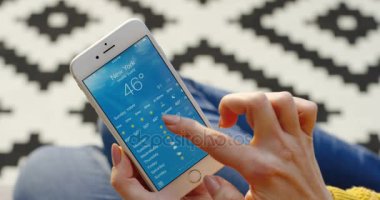 New York - 01 Aralık 2017: hava tahmini dikey beyaz smartphone cep telefonu ile kontrol eller. Desenli arka plan. Yakın çekim