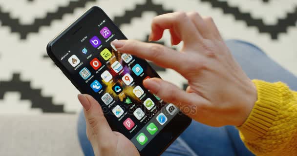 ニューヨーク – 2017年12月01日:女性の手を閉じて垂直黒のスマートフォンでNike Trainingアプリを開きます。背景には青地模様の絨毯が敷かれている。. — ストック動画