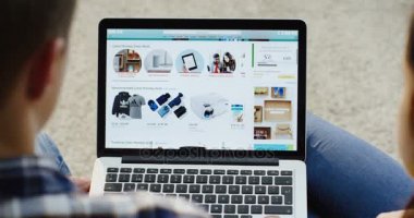 New York - 01 Aralık 2017: kadın ve adam Amazon Web sitesinde dizüstü bilgisayar Cyber Pazartesi kaydırma omuz görünümü üzerinde. Yakın çekim. Üstten Görünüm