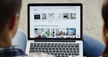 New York - 01 Aralık 2017: Close up üzerinden omuz görünümü kadın ve ev için bazı ürünler seçmek için dizüstü bilgisayarda IKEA Web sitesini kullanarak dostum. Üstten Görünüm