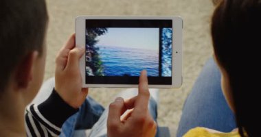 New York - 01 Aralık 2017: yakından oturmuş, fotoğraf beyaz tablet cihaza yatay kaydırma çift omuz görünümü üzerinde. Yakın çekim. Üstten Görünüm