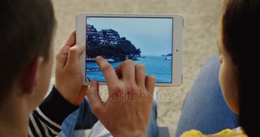 New York - 01 Aralık 2017: Close up üzerinde görünümü çift oturma birbirine yakın, beyaz tablet bilgisayarda kayan fotoğraflar üzerinde yatay olarak omuz. Üstten Görünüm