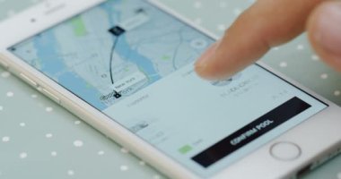 New York - 01 Aralık 2017: İn yakın parmak kaydırma ve Uber app beyaz Smartphone rota seçimi mans.
