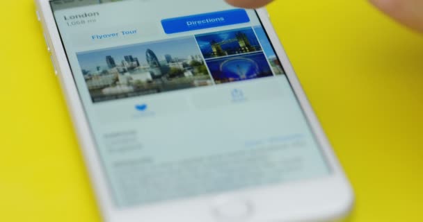New York - 01 Dec, 2017: Närbild av de mans finger prydande maps-appen på den vita smarta telefonen som liggande på tabellen gul. — Stockvideo
