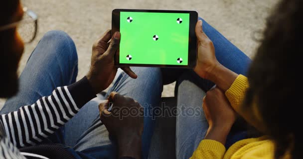아프리카계 미국인 여자와 남자 녹색 화면으로 검은 태블릿 컴퓨터를 들고와 수평으로 움직임을 추적, 스크롤 및 녹화, 그리고 몇 가지 서로 다른 복용 보다 사람 손. 크로마 키 — 비디오