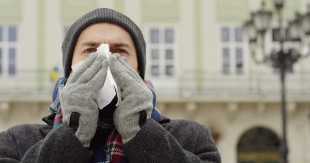 寒い日に街にナプキンでくしゃみ白人の病気男性の肖像画のショット クローズ アップ — ストック動画