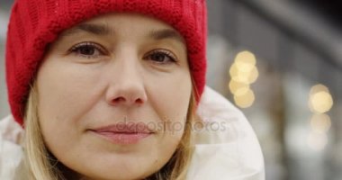 Kamera seyir ve kışın gülümseyen red hat sarışın kadının yüzüne portresi. Açık havada. Yakın çekim
