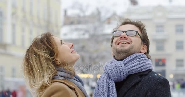 一对快乐的中年情侣在冬日里 在美丽的小镇中间下雪的时候 抬头大笑 肖像拍摄 — 图库视频影像