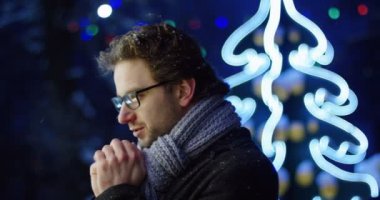 Portre yakışıklı Noel süslenmiş sokağın gecesi ellerini ısınma bardaklarda tarafındaki. Açık. Yakın çekim