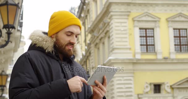 Genç Yakışıklı Bir Şapka Sıcak Kış Tablet Bilgisayarında Kaydırma Ceket — Stok video