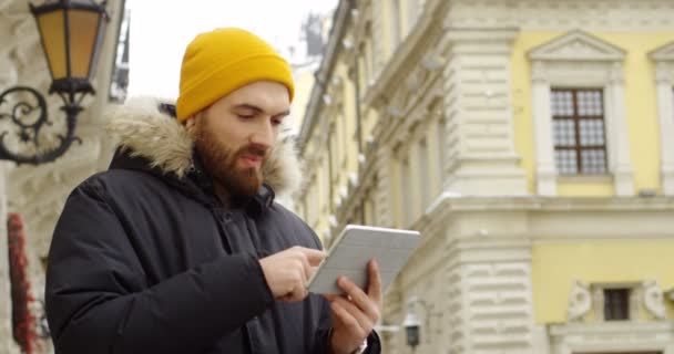 Jovem Homem Atraente Com Uma Barba Chapéu Amarelo Casaco Inverno — Vídeo de Stock