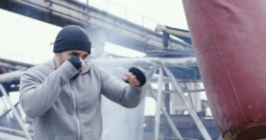 Bir sportif gri hoodie ve soğuk sisli günde bir çanta eski fabrika Harabeleri üzerinde delme şapka bir sakallı yakışıklı adam. Dışarıda