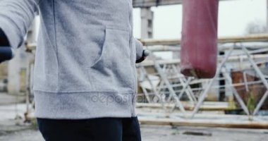 Çekici beyaz adamın gri eğitim ceket sakallı ip atlama abondened alanında sisli sabahı atlama bir kukuleta ile yakın çekim. Açık