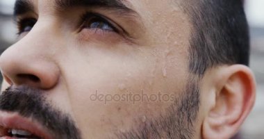 Çekici erkek yüz sakallı kapatın. Adam gökyüzünde bir umutla bakan ve kameraya kurnaz bir bakışla yüzünde ter düşer daha. Motivasyon resim. Portre. Açık