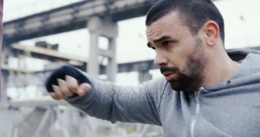 Çekici erkeği boks başladı kırmızı çanta üzerinde kötü sisli havalarda yapma sakallı kapatın. Dışarıda fabrika mahveder. Portre vurdu