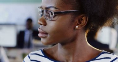 Afrikalı-Amerikalı kadın tarafında ve kameraya gülümseyen daha seyir bardaklarda kapatın. Bulanık ofiste işçi arka plan ile. Portre vurdu